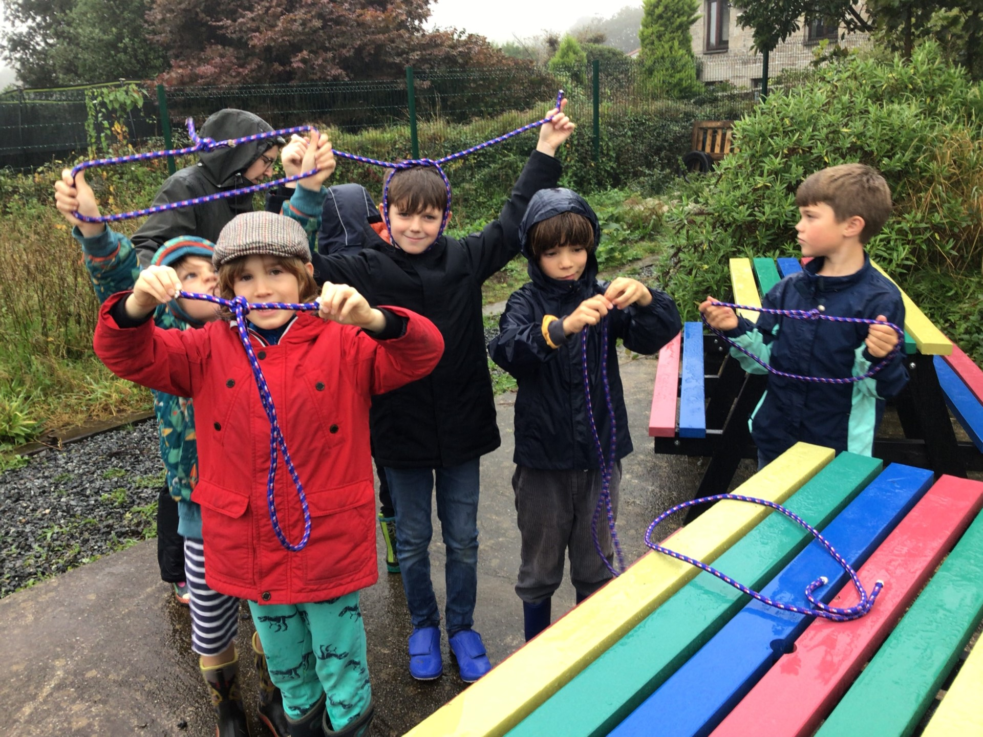 children practicing knot tieing